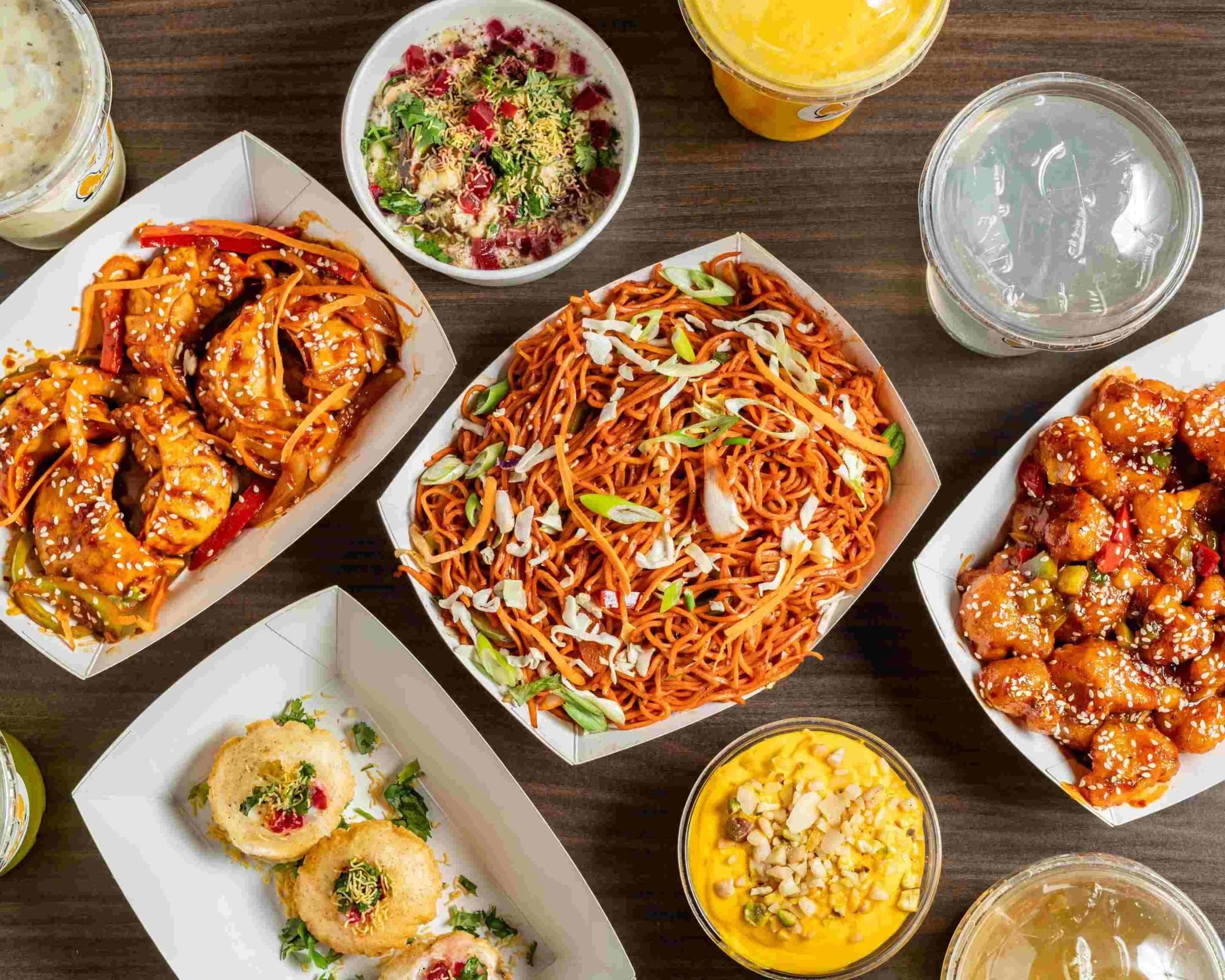 Indian street food spread from The Snack Fusion — noodles, momos, chaat, and drinks